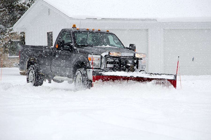 Pickup truck plowing snow during a winter storm